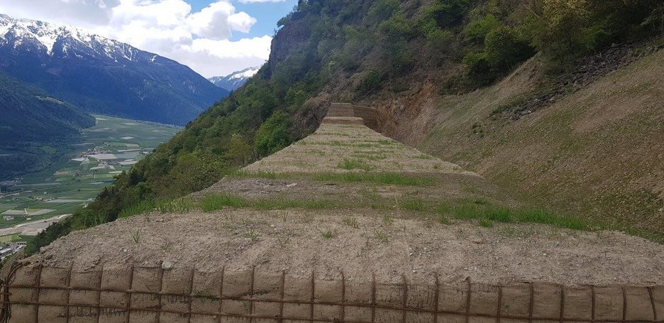 Alpin Geologie: Construction of a rockfall wall above the village of Ciardes